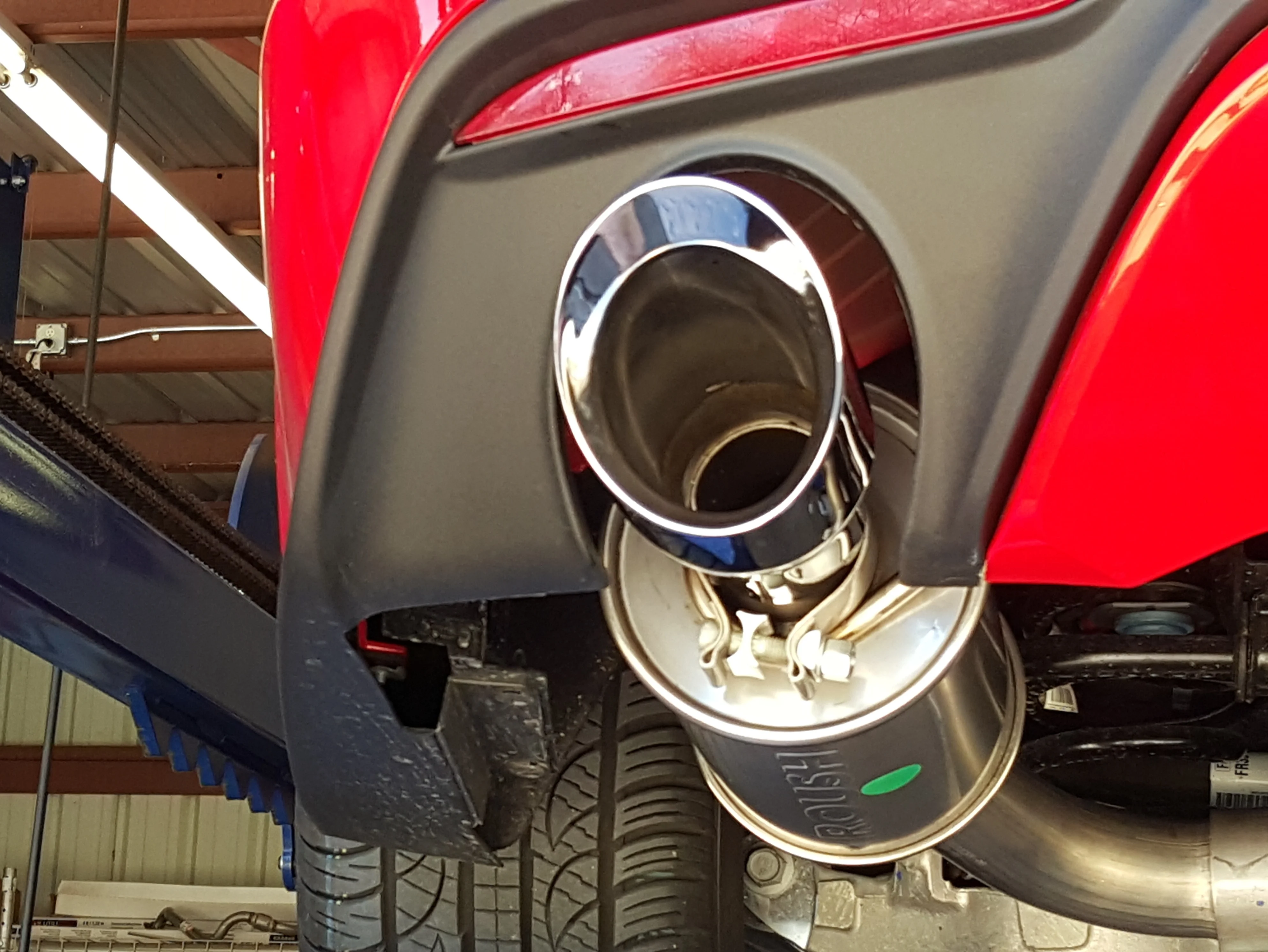 Polished Roush stainless exhaust tip installed on a red performance vehicle at Vorenza Auto Repair