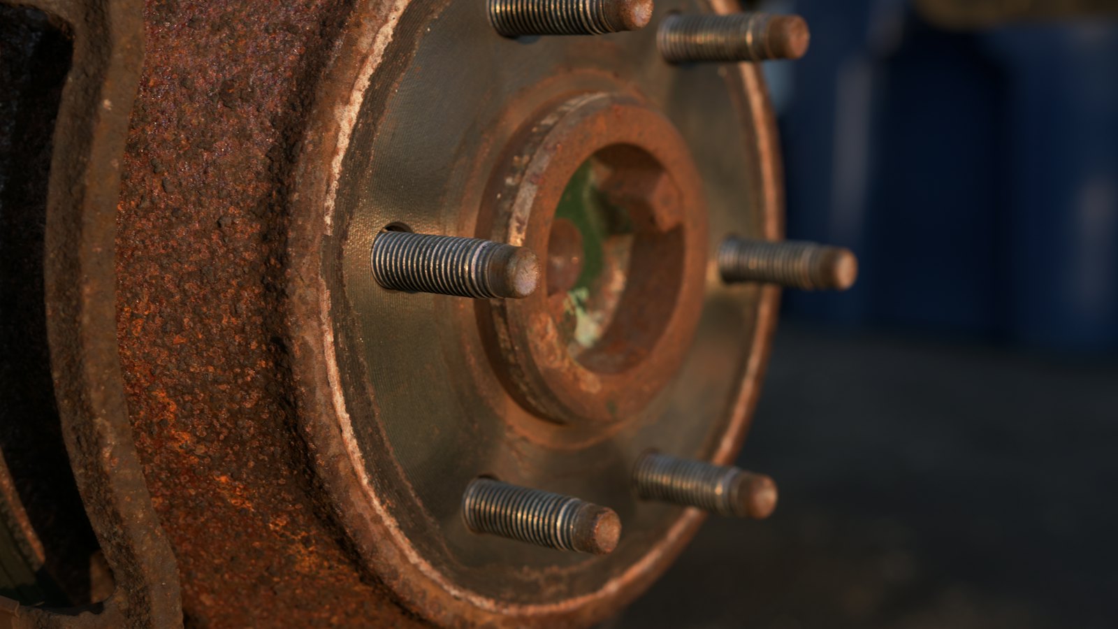 Brake rotor covered in heavy orange rust around the wheel studs, the kind of buildup that causes scraping and squealing brakes