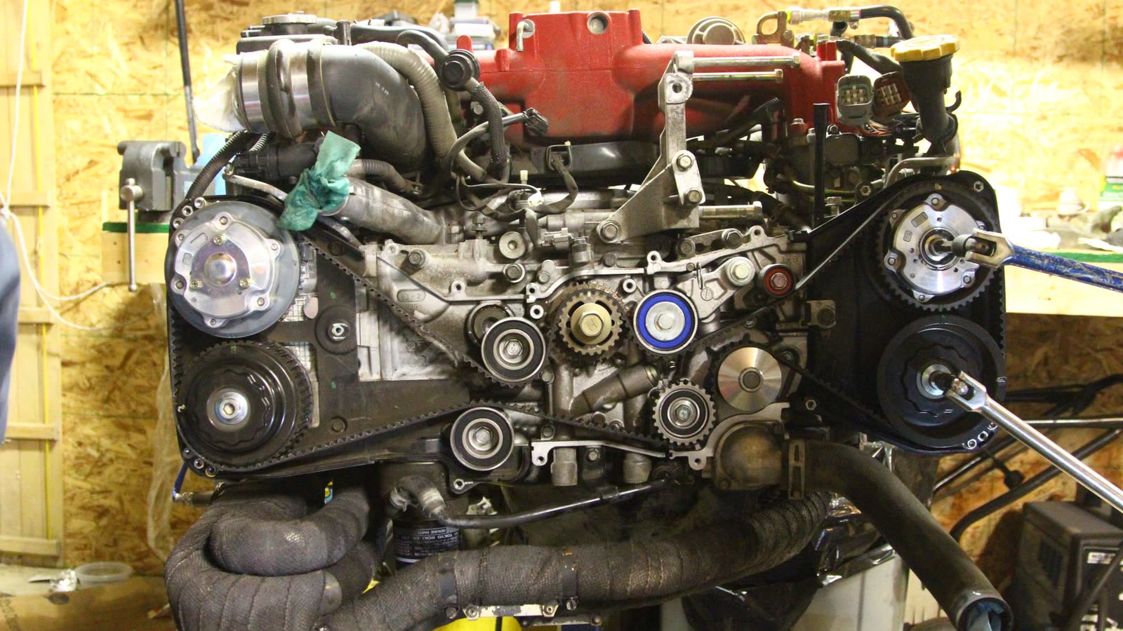 Boxer engine out of the car on a stand, with the timing belt, pulleys and tensioner exposed